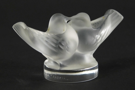 A 20thC Lalique frosted and clear glass figure group of two birds, signed, 5cm high.