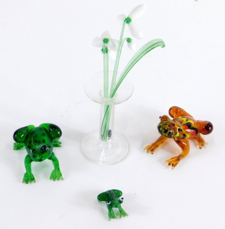 A 20thC Lalique style figure of a frog, in amber and Nailsea style glass, unsigned, 5cm long, floral arrangement and two other frog figures. (a quantity)