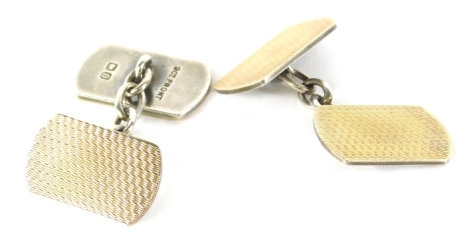 A pair of silver-gilt cufflinks, partially engine turned with chain centres, 1cm high, in fitted case.