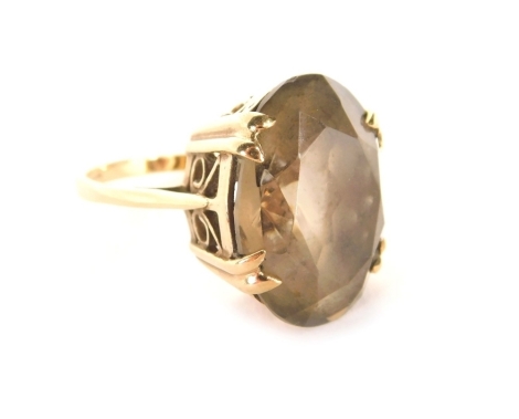 A 9ct gold smoky quartz dress ring, with oval faceted smoky quartz in four twin claw setting in a raised and pierced basket, ring size O, 6.9g all in.