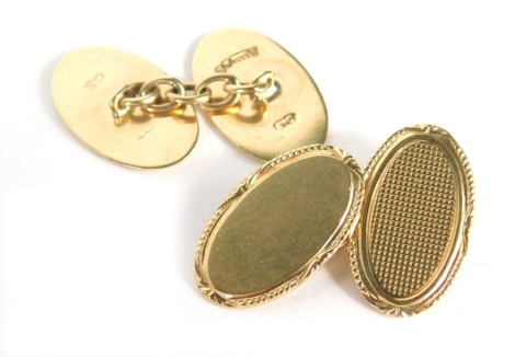 A pair of 9ct gold oval engine turned cuff links, each with a rope twist and fan design border, one half plain the other with engine turned cross hatch detailing, 7.1g.