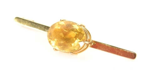 A citrine bar brooch, the oval stone in six claw basket setting, on a plain single pin, 5.5cm wide, 7.3g all in.