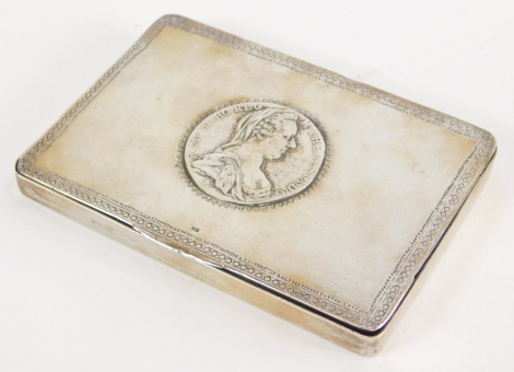 An early 20thC Continental silver coloured metal, silver snuff box, centred by a Maria Theresa Thaler coin, with an outer stamped decoration and thumb mould handle, with plain interior, marked to the lid, 12cm wide.