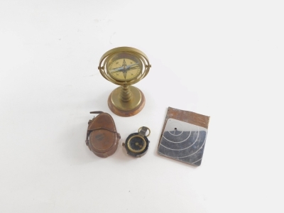 A 20thC brass table compass, 21cm high, a Verner's patent compass in leather case and a World War II heliograph plane spotting mirror in a leather case. - 2