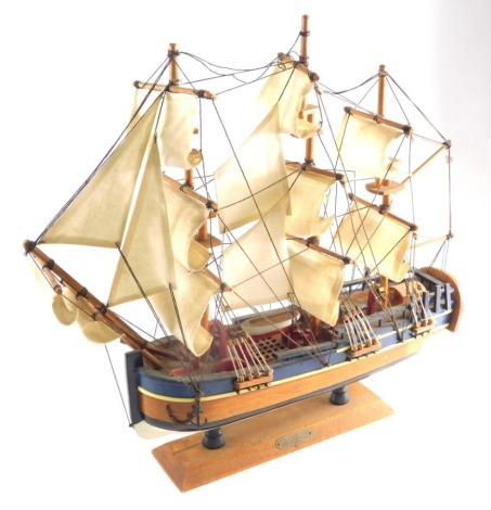 A 20thC wooden model of HMS Endeavour, with realistic deck and rigging on a wooden plinth base, 46cm high.