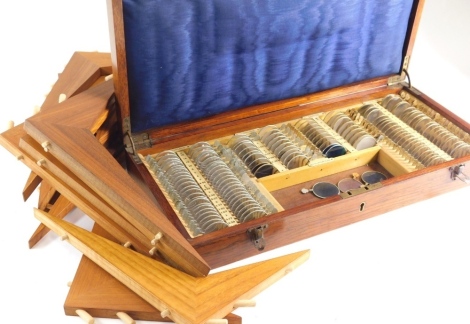 An early 20thC oak cased optical opticians set, and a quantity of various brass bound lenses, various wooden V shaped sections in a fitted case, 49cm wide.