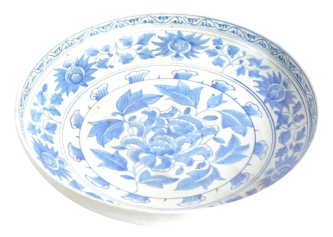 An 18thC Chinese style blue and white pottery dish, decorated with flowers, 35cm diameter.