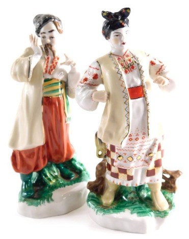 Two 20thC Ukrainian porcelain figures, to include gentleman in pantaloons in green and orange, 27cm high, etc. (2)