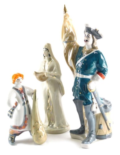 A Ukrainian porcelain figure of Peter the Great, polychrome decorated, in green and orange, 39cm high and two other figure groups. (3)