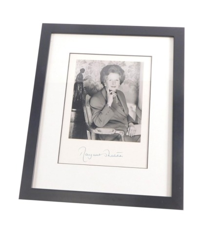 A 1990's photograph of Margaret Thatcher, seated in a chair, signed to the mount, 21cm x 18cm, mounted and framed.