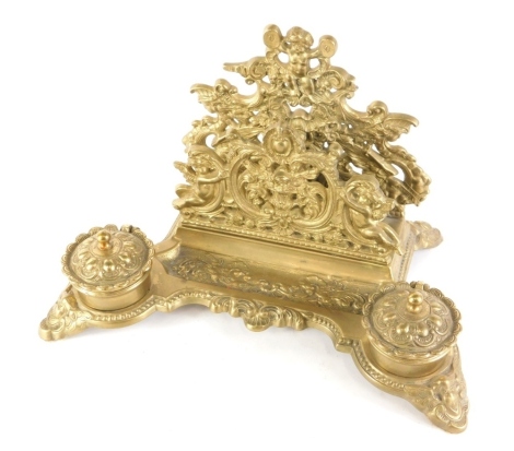 A Continental brass desk stand, decorated in rococo style, with a letter recess, pen tray and two inkwells, 31cm wide.