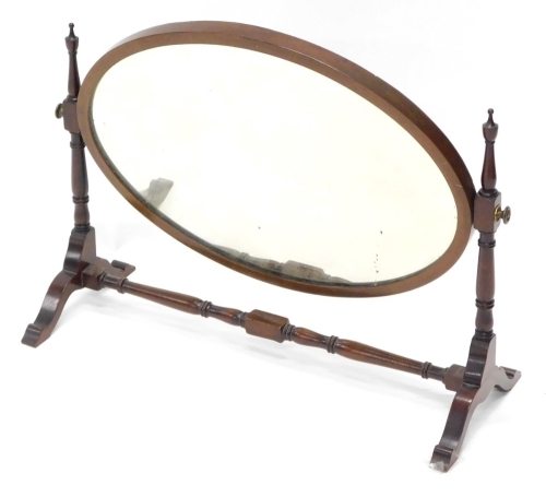 A mahogany dressing table mirror, with oval plate on shaped supports, 64cm wide.