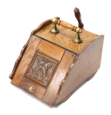 An Edwardian oak coal box, with brass handle and shovel, with carved floral panel.