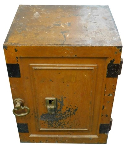 A late 19th/early 20thC iron safe, painted to simulate wood, with panel door, enclosing a part fitted interior, brass swivel handle and escutcheon iron key, 55cm high, 42cm wide, 37cm deep.