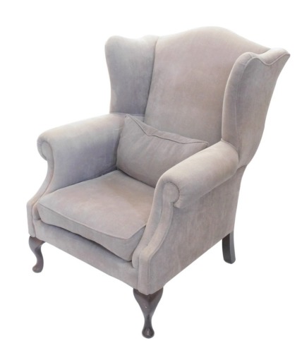 A mahogany wingback chair, George III style, upholstered in grey fabric on cabriole legs with pad feet.