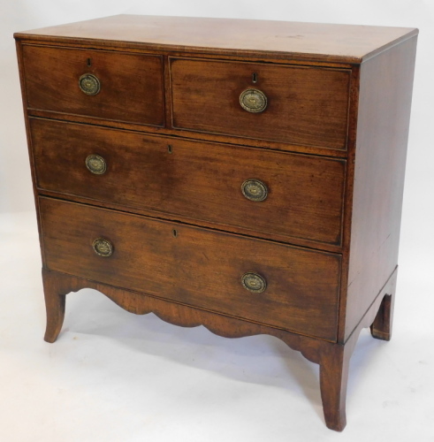 A late George III mahogany chest of drawers, with a plain top above two short and two long drawers, each with oval brass handles on splayed feet, 90cm high, 92cm wide.