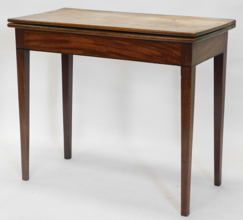 An early 19thC mahogany tea table, the D shaped top with a reeded edge, over three plain panel frieze, on turned tapering legs, headed by lozenges with brass castors, 74cm high, 90cm wide.