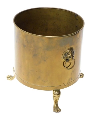 A 20thC brass coal bucket, with lion mask handles, partially studded on hairy paw feet, 41cm high, 37cm diameter.