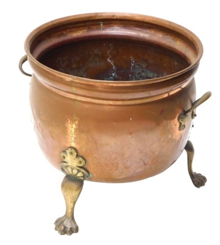 An early 20thC copper coal bucket, of bulbous form, with C handles, on hairy paw feet, 41cm high, 45cm diameter.