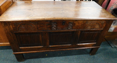 An 18thC oak coffer, of rectangular form with carved front, plain panels and block stiles, 76cm high, 134cm wide, 58cm deep.