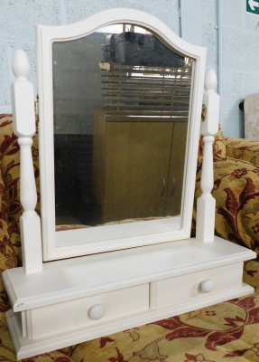 A table mirror in white, with turned supports, plain serpentine glass and two drawers, 58cm high.