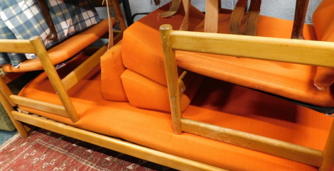 A vintage Habitat teak three piece suite, comprising two armchairs, 71cm high. and three seater daybed, in orange material, purchased in 1963. The upholstery in this lot does not comply with the 1988 (Fire & Fire Furnishing) Regulations, unless sold to a 