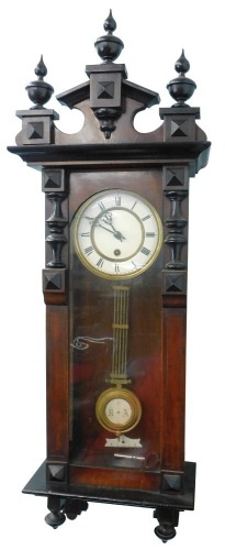 An early 20thC walnut cased Vienna wall clock, with broken pediment, cream coloured enamel dial with Roman numerals, etc., 87cm high.