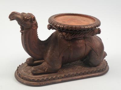 An early 20thC Indian wooden stand carved in the form of a recumbent camel
