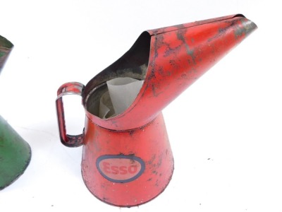 Three Esso oil cans, comprising two red oil cans stamped Esso, 31cm and 26cm high, and a green quart Esso jug, 28cm high. (3) - 4