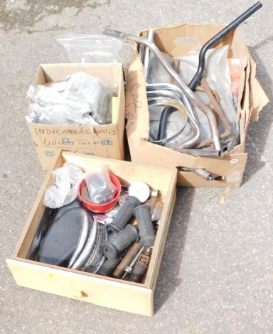 A group of motorcycle parts, comprising handle bars, grips, Triumph badges, etc. (3 boxes)