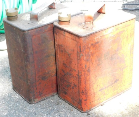 Two metal petrol cans, each painted in a red/orange, 29cm high.`