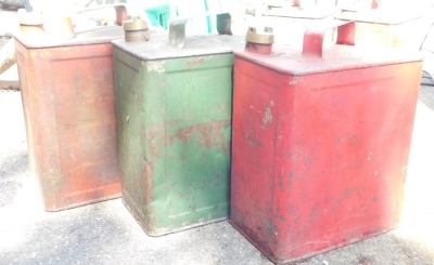 Three metal petrol cans, two red, the other green, each 29cm high. (3)