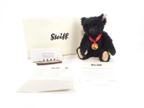 A Steiff Titanic centenary bear, black, 26cm high, with a small model of the Titanic, boxed with certificate.