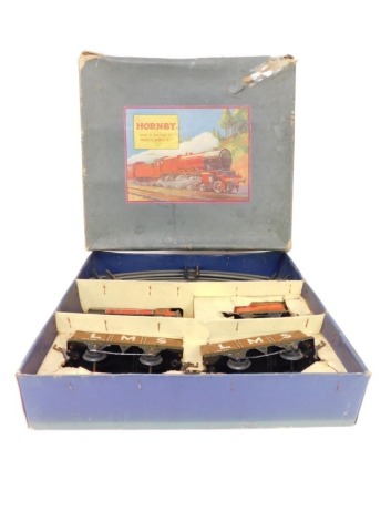 A Hornby tin plate clockwork O gauge M1 goods set, including 0-4-0 tank locomotive and tender, two LMS four plank wagons and track, boxed.