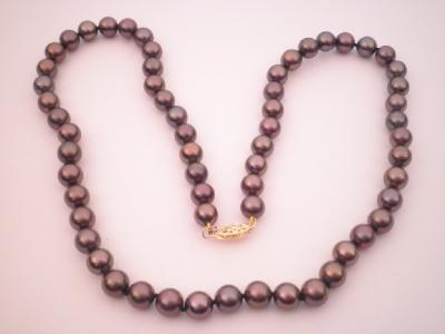 A string of black pearls with yellow metal clasp