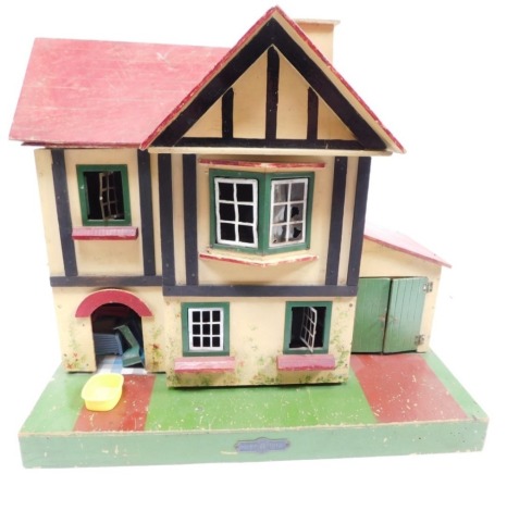 A mid 20thC Amersham Toys mock Tudor dolls house, with fixed roof, front opening and garage, with accessories, 46cm high.