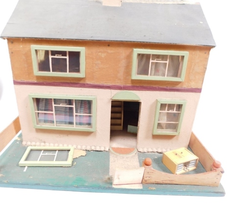 A mid 20thC dolls house, with fixed roof, open front on wooden stand, and a small quantity of accessories, furniture, etc., 60cm wide.