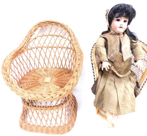 A 19thC Simon and Halbig porcelain doll, with blink eyes, open mouth, showing teeth, black hair, articulated limbs, with clothing, 22cm high, and two wicker dolls chairs. (3)