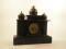 A French and black slate mantel clock in the form of a portico with three domes