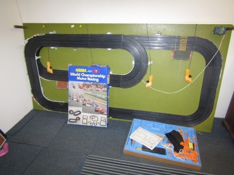 A large Aurora track layout, with arch two sectional track on green ground with some accessories, four lanes, 243cm x 142cm, and an Aurora World Championship Motor Racing sets partially boxed. (2)