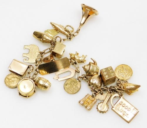 An oval link identity charm bracelet, yellow metal with twenty four charms as fitted, on a bolt ring clasp, most charms and bracelet stamped 9ct, 36.5g.