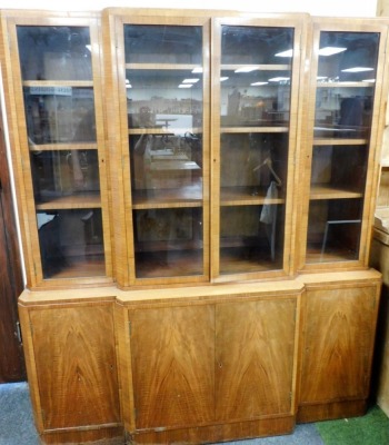 An Art Deco walnut breakfront bookcase, the top with four glazed doors, each enclosing three shelves, over four cupboard doors enclosing shelves, 176cm high, 152cm wide, 95cm deep. - 2