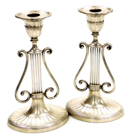 A pair of Victorian silver Neo-Classical candlesticks, of lyre form raised on an oval fluted base, 20.5cm high, Harrison Brothers & Howson, London 1899, loaded, 19½oz gross.