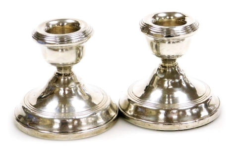 A pair of Elizabeth II silver squat candlesticks, with loaded bases, Birmingham 1962, 7cm high.