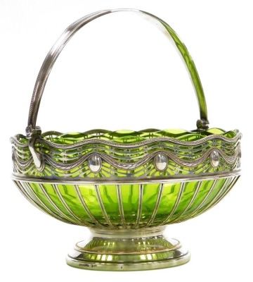 An early 20thC WMF silver plated basket, with an inset pale green glass bowl, pierced and embossed wavy rim above an open frame and a circular foot, impressed marks, 23cm diameter.