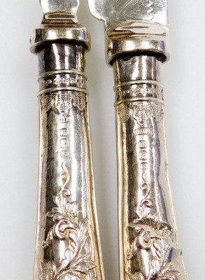 A late Victorian part set of silver handled fish knives and forks, comprising six forks and five knives, each handle profusely decorated with leaves, and two further butter knives of differing design, in fitted case. - 3