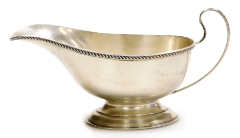 A George V silver sauce boat, with a gadrooned border on pedestal base, Birmingham 1927, 5oz, 7cm high.