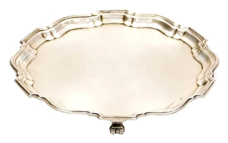 A George V silver salver, with pie crust border raised on three scroll feet, Birmingham 1930, 7¼oz, 18cm diameter.