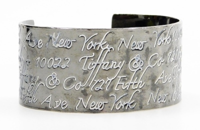 A cuff bangle, with white enamel engraved decoration, repeating '127 5th Avenue New York', and New York 122, stamped 1997 Tiffany & Co.925, boxed, 1.7oz - 2