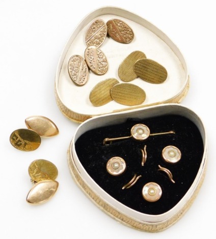 A mid century gentleman's dress set, yellow metal and seed pearl set, comprising tie pin and three shirt buttons, boxed, together with three pairs of gold plated oval link cufflinks.